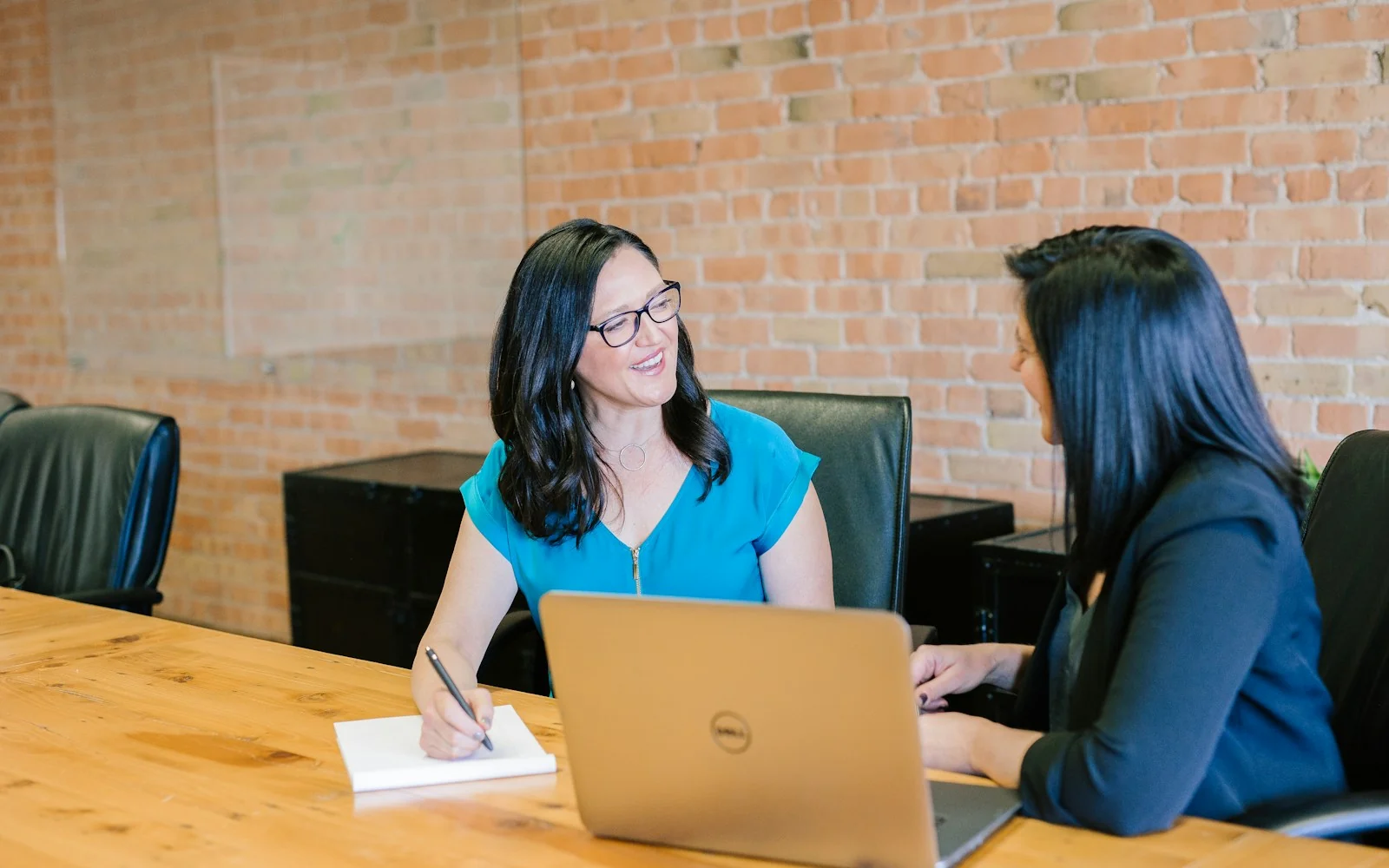 Two professionals discussing work in a bright office