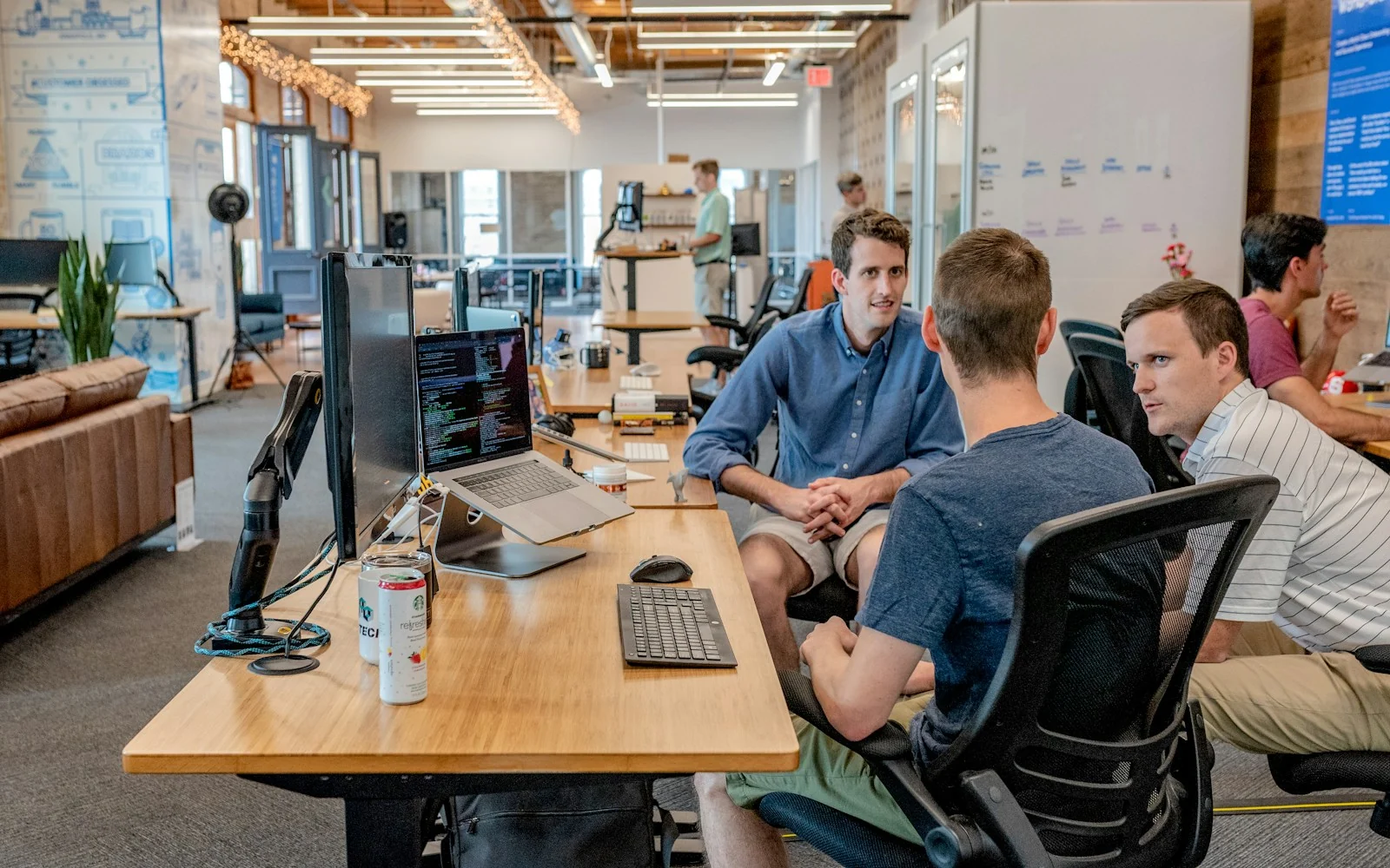 Software team collaborating around computers in a modern office